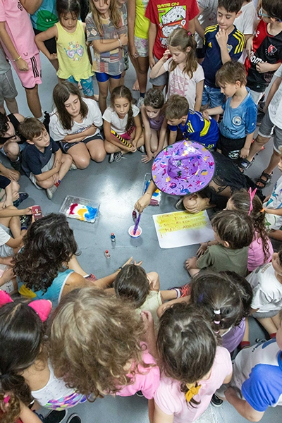 alumnos motrinfan en círculo pintando