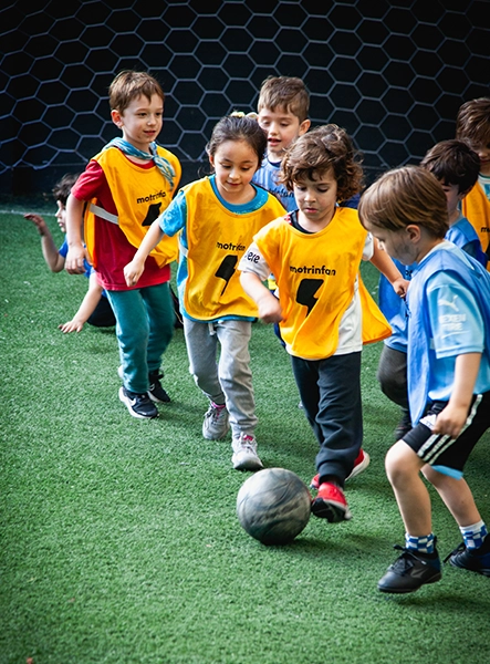 alumnos motrinfan corriendo jugando al futbol